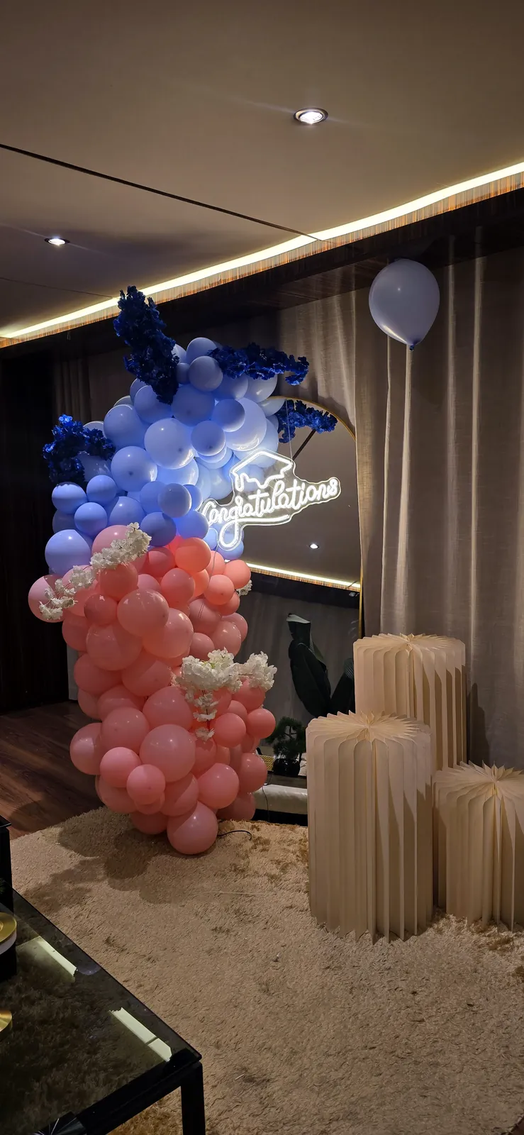 Colonne de ballons bleu marine et corail avec des ballons argentés métallisés et des présentoirs colonnes dans un salon